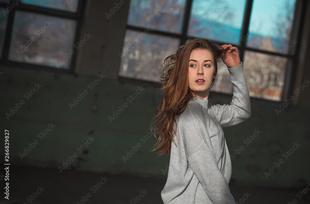 Beautiful teenage girl touching her beautiful long red hair in gray sweater Beautiful teenage girl touching her beautiful long red hair in gray sweater