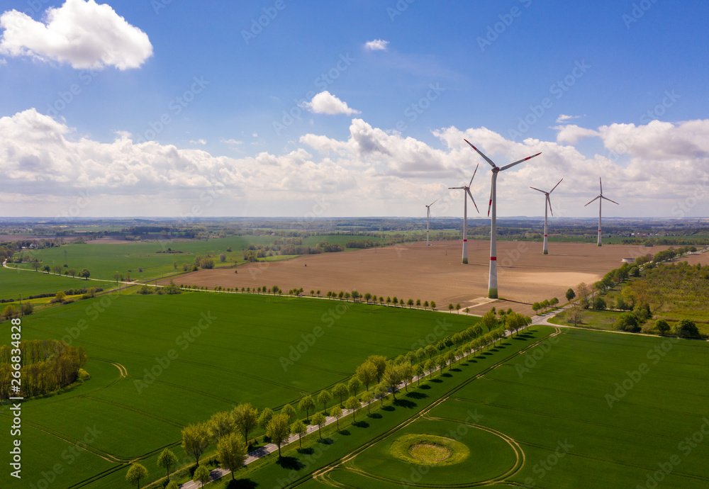 aerial view of agricultural fields with windmill or wind turbines in the background aerial view of agricultural fields with windmill or wind turbines in the background