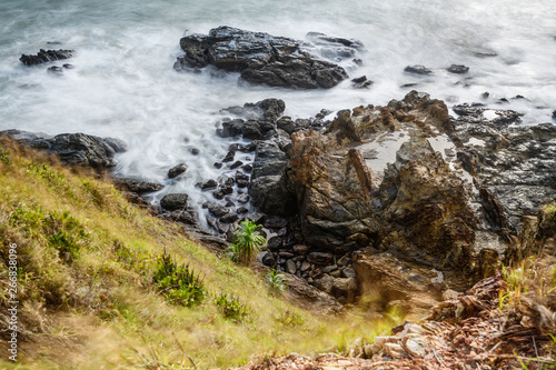  Top view of wave crashing the rock or stone coast with emerald clear water
