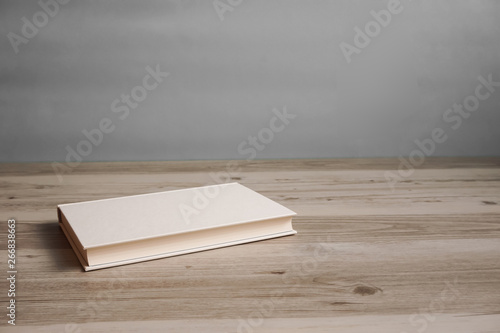 One book on a table or desk. テーブルの上に置かれた一冊の本