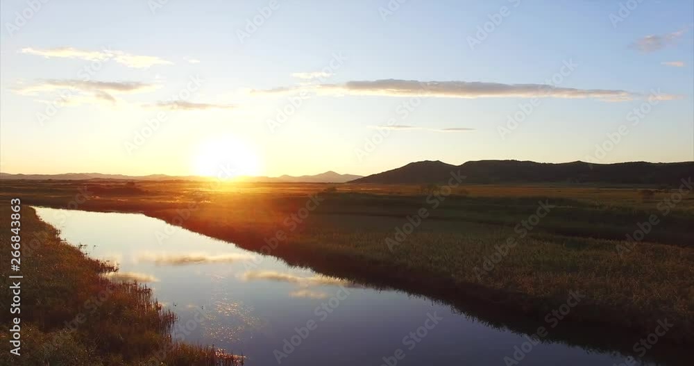 Magnificent aerial view of summer landscape, flying above small calm river running among endless green fields. Beautiful warm sunset. Russia Magnificent aerial view of summer landscape, flying above small calm river running among endless green fields. Beautiful warm sunset. Russia