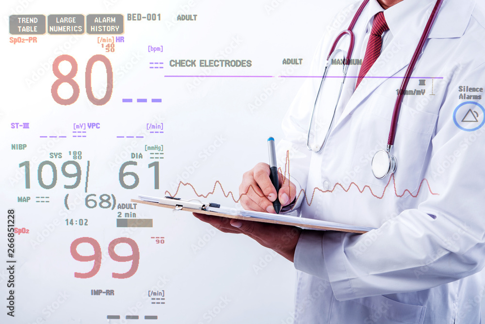 Doctor hold notepad in hand with electrocardiogram monitor showing patient heart rate, medical rescue concept. Doctor hold notepad in hand with electrocardiogram monitor showing patient heart rate, medical rescue concept.