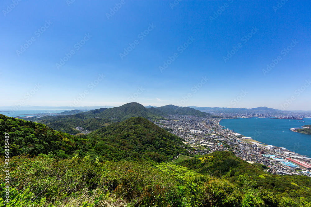 Naklejka premium 風頭から見た、関門海峡と北九州市街地と北九州を代表する山々（高塔山、皿倉山、福智山、足立山、貫山、戸の上山 遠く由布岳を望む）