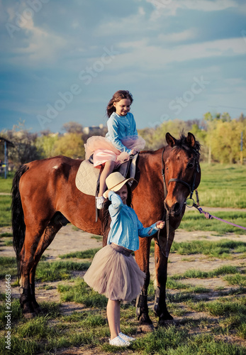 Cute sisters posing with horse. © Alona