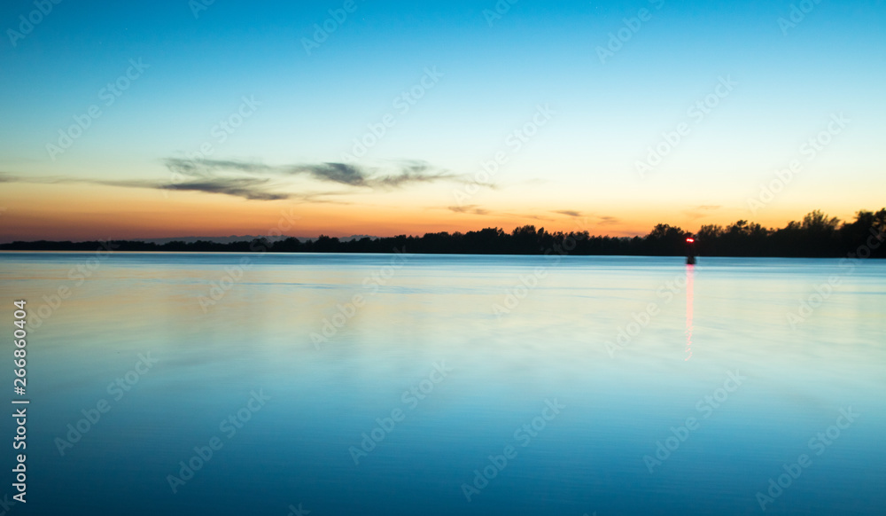 Fototapeta premium scenic blue sunset time on the river with smooth water