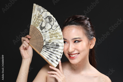 Young beautiful Asian woman makeup dark background 