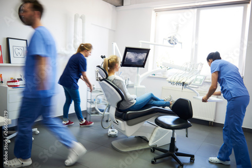 Blurred view of dentists and woman in dentist s Clinic