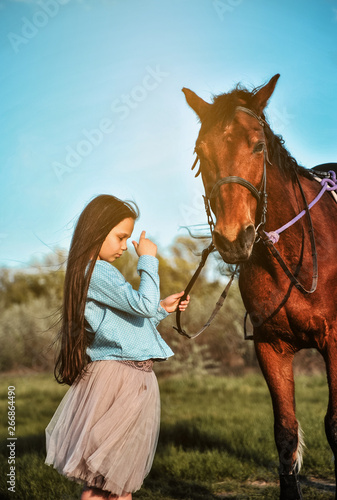 Beautiful girl with horse on the grass. Friendship concept. © Alona