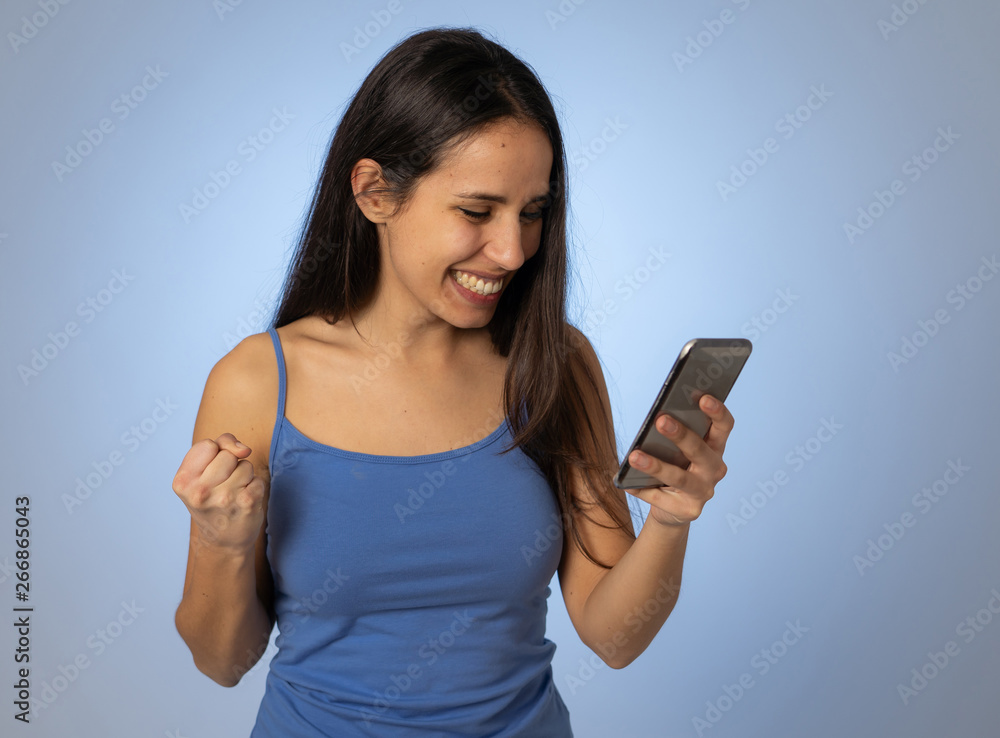 Attractive young woman looking at mobile smart phone shocked and surprised having lost of likes Attractive young woman looking at mobile smart phone shocked and surprised having lost of likes
