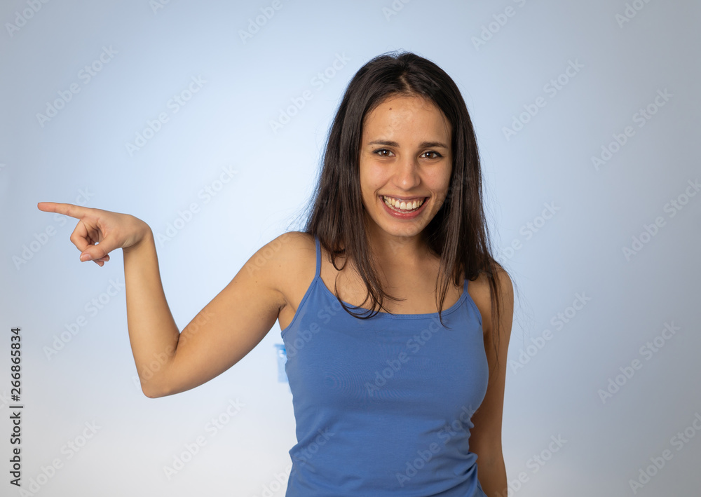 Charming smiling young woman pointing finger at empty copy space for advertisement Charming smiling young woman pointing finger at empty copy space for advertisement
