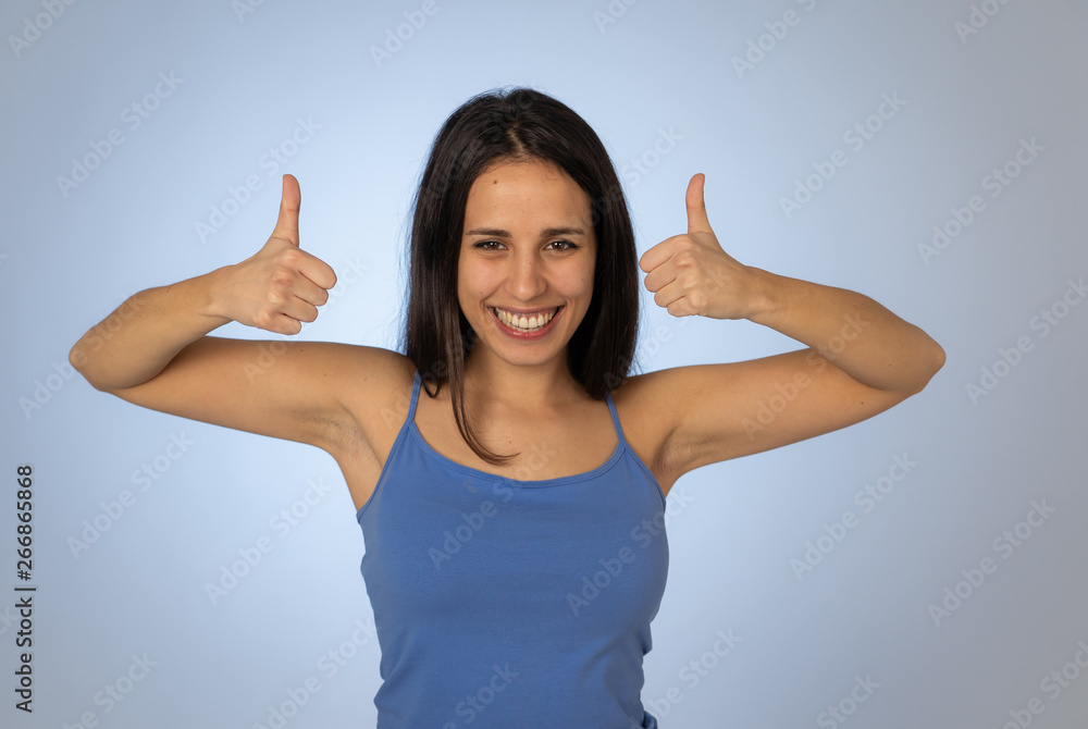 Portrait of pretty teenager making thumbs up gestures feeling happy and successful Portrait of pretty teenager making thumbs up gestures feeling happy and successful