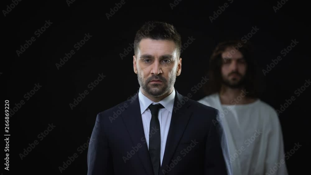 Praying businessman joining hands, messiah standing behind, spiritual support Praying businessman joining hands, messiah standing behind, spiritual support