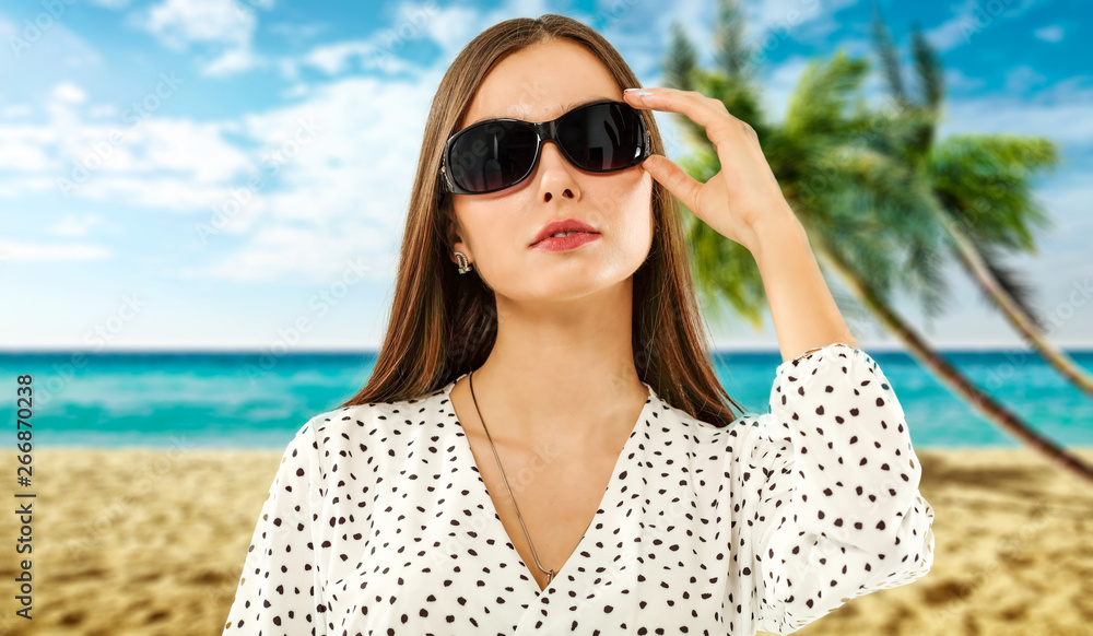 Slim young woman with sunglasses and beach landscape of palms. Slim young woman with sunglasses and beach landscape of palms.