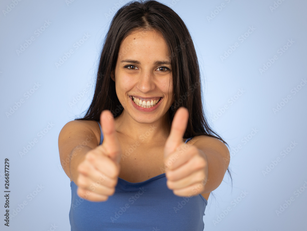 Portrait of pretty teenager making thumbs up gestures feeling happy and successful Portrait of pretty teenager making thumbs up gestures feeling happy and successful
