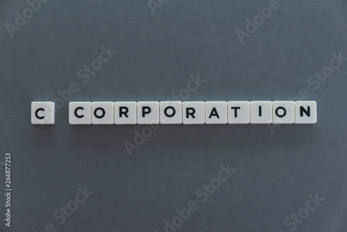 C corporation word made of square letter word on grey background.