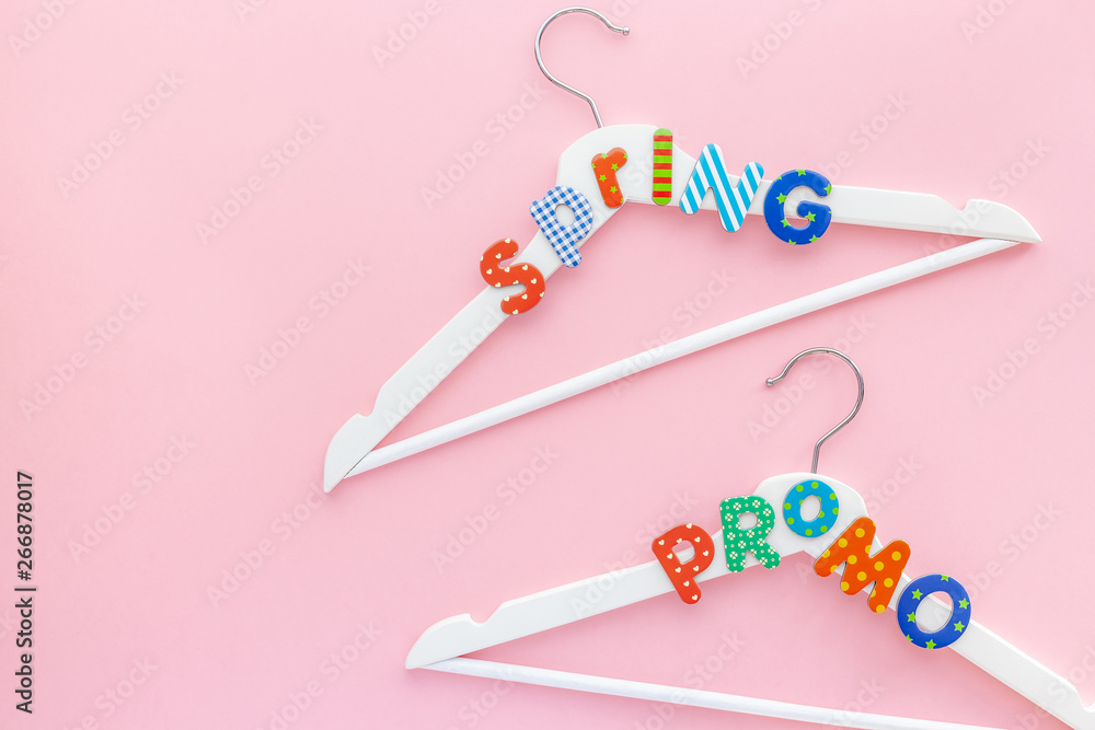 White hangers with sale text on pink background White hangers with sale text on pink background