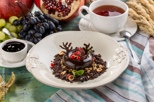 Black Forest chocolate dessert with cup of tea on textile napkin