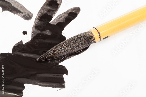 Foto black colored tip of paintbrush over ink stains