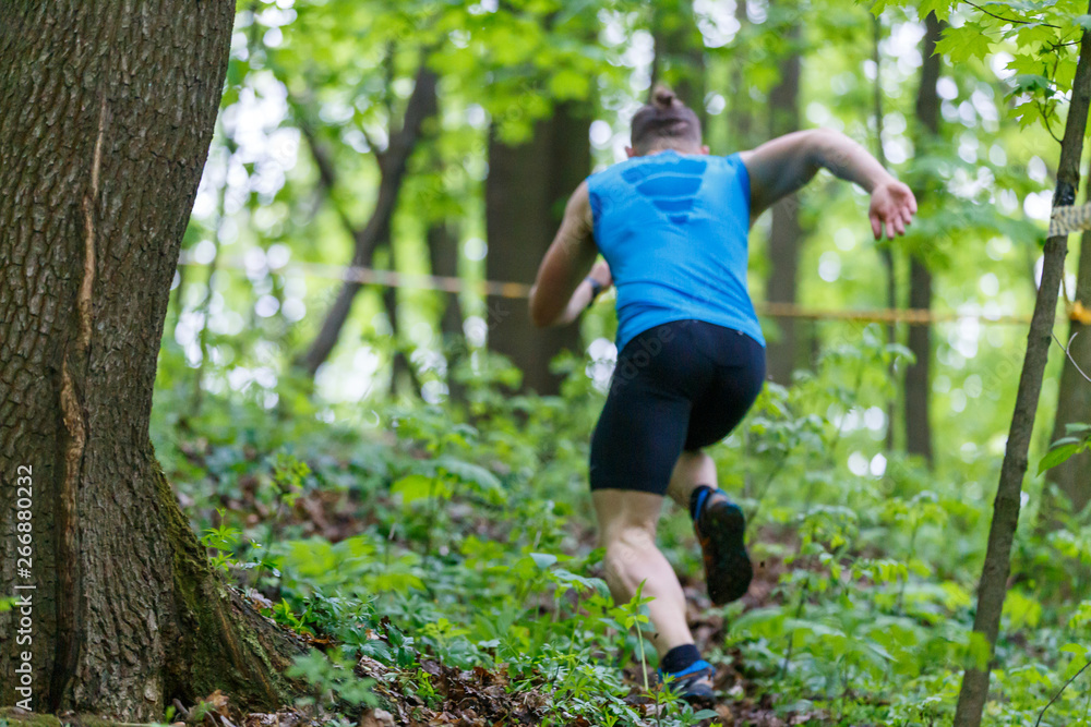 Young sporty man running trail cross in the forest Young sporty man running trail cross in the forest
