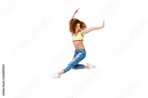 junge Frau mit langem, lockigem Haar die in der Luft ist