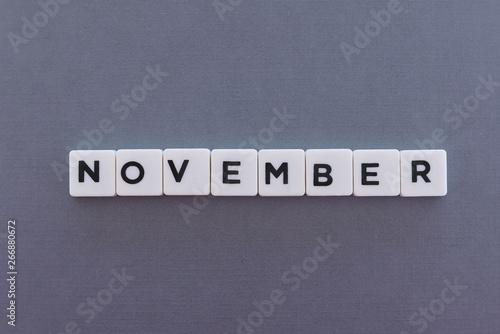 November word made of square letter word on grey background.