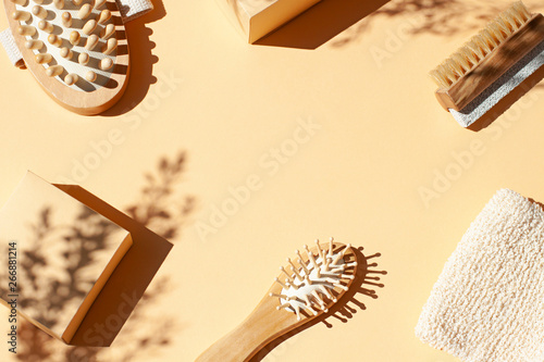 Bathroom, spa accessories concept flat lay on the beige background. Top view frame with hairbrush , nailbrush with pumice stone, bath mitt and massaging brush. Copy space photo