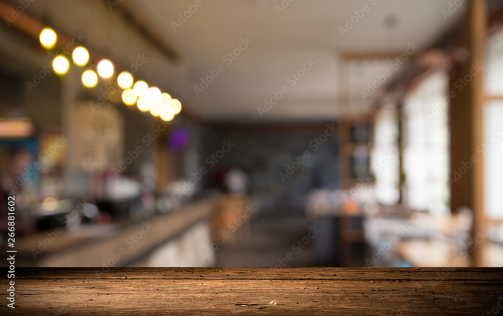image of wooden table in front of abstract blurred background of resturant lights