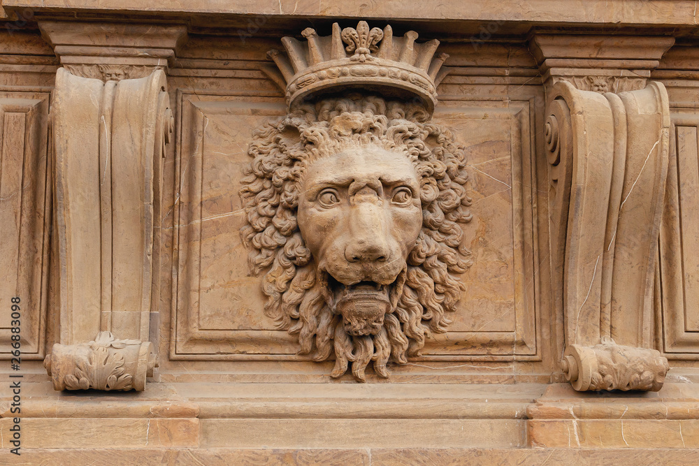 Plaster sculpture of a lion head on the facade of a building in Florence, Italy