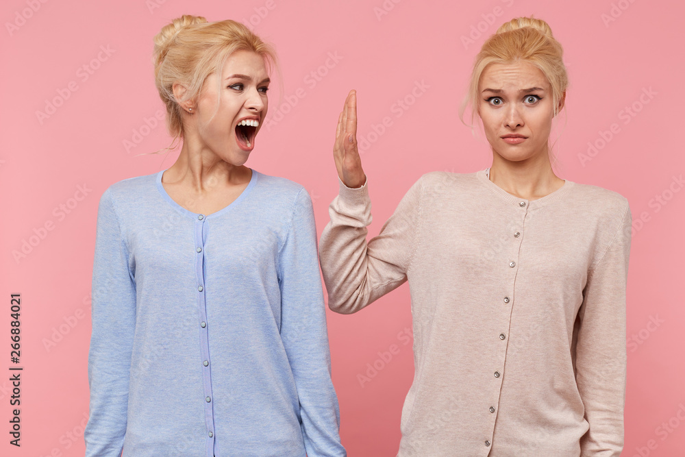 Сonflict between the twins, one of the sisters refuses to listen to the cry of another isolated over pink background. Сonflict between the twins, one of the sisters refuses to listen to the cry of another isolated over pink background.