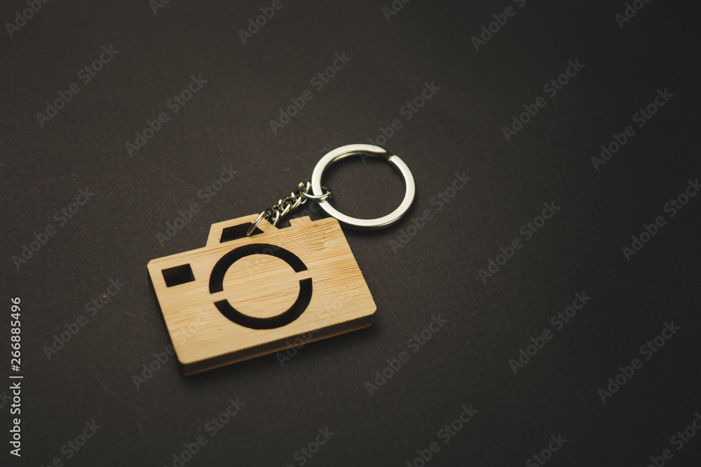 wooden trinket in the form of a camera on a black background. keychain wooden trinket in the form of a camera on a black background. keychain