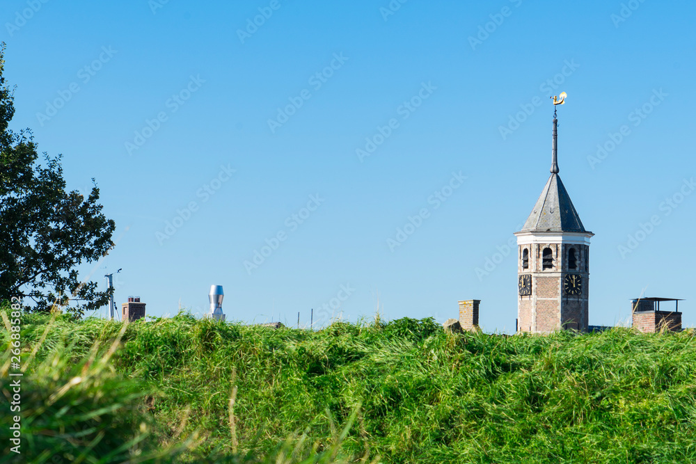 tower of city hall and dike in Willemstad, The Netherlands. Blue sky, space for text