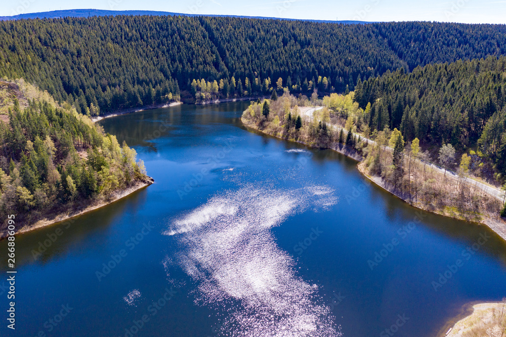 Aerial view of a flight over a reservoir in the Harz Mountains, a German low mountain range, with mountains and forests