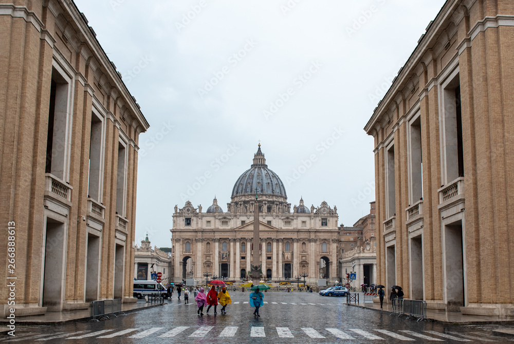 Persone con ombrelli e impermeabili colorati con lo sfondo della Basilica di San Pietro, Citta del Vaticano Roma