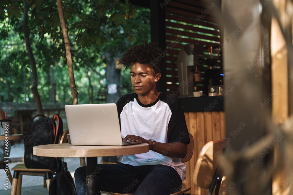 Young african man using laptop computer at the cafe Young african man using laptop computer at the cafe