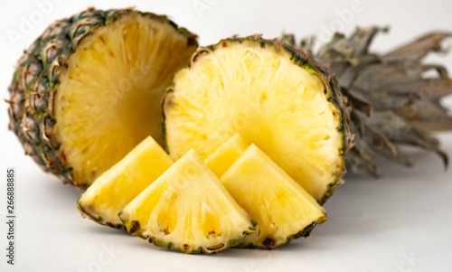 Delicious fragrant appetizing pineapple cut into slices for dessert with a light background