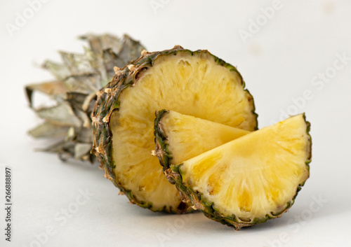 Dessert of pineapple fragrant tasty cut into appetizing slices on a white background