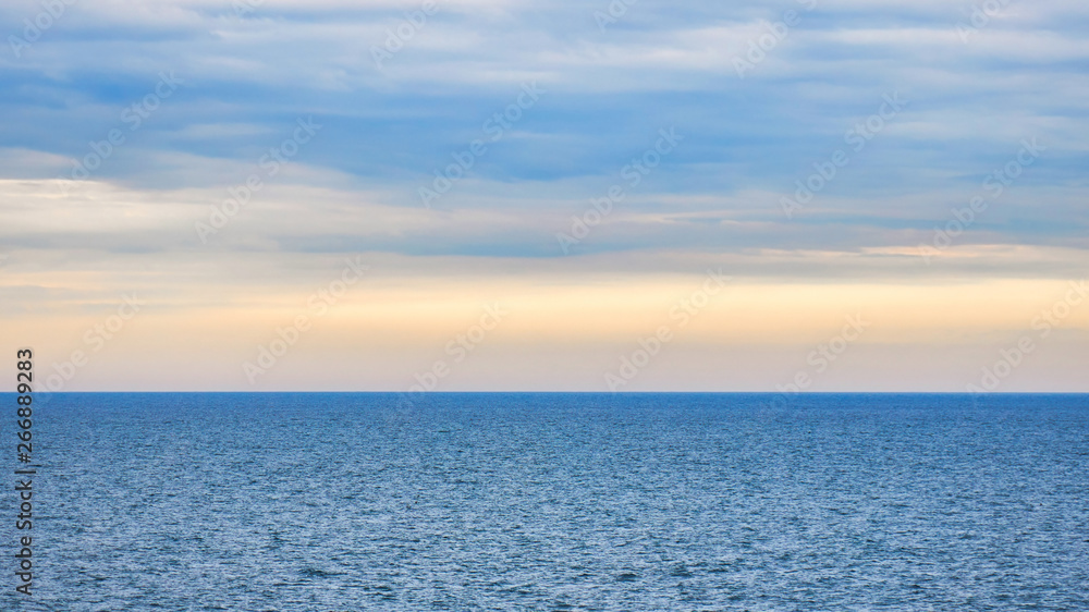 Fototapeta premium Infinite ocean landscape in a cloudy sunset time