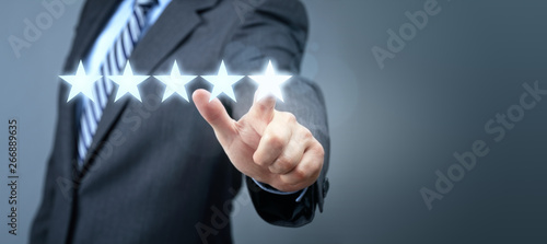 Fotografia Businessman pointing to five star service rating symbol