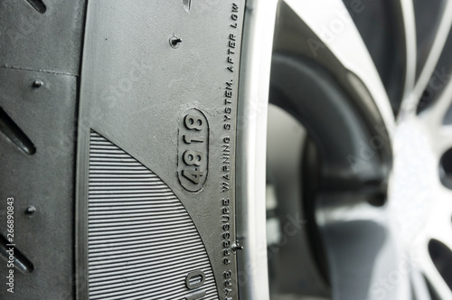 Картината върху платно Close up of DOT number on tire which specify to week and year of product for determine the lifetime of the tire car on blurred alloy wheel background