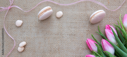 Mother's day background with tulips bouquet and pink macarons.