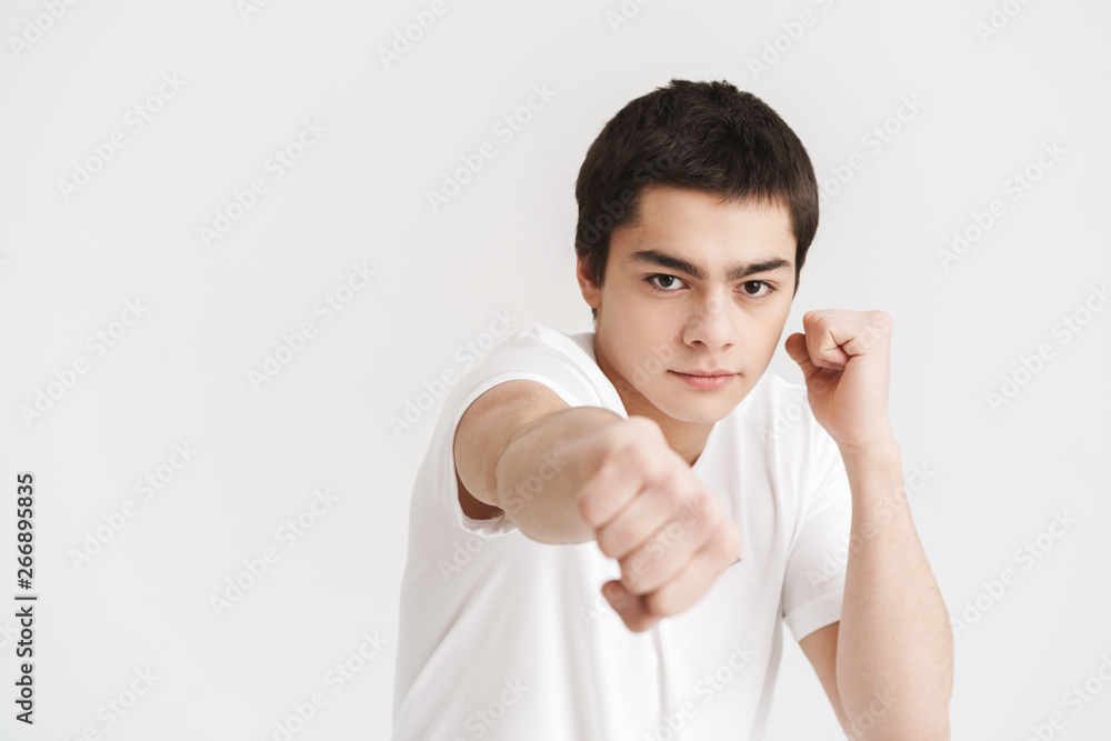 Confident young sportsman doing boxing exercises Confident young sportsman doing boxing exercises