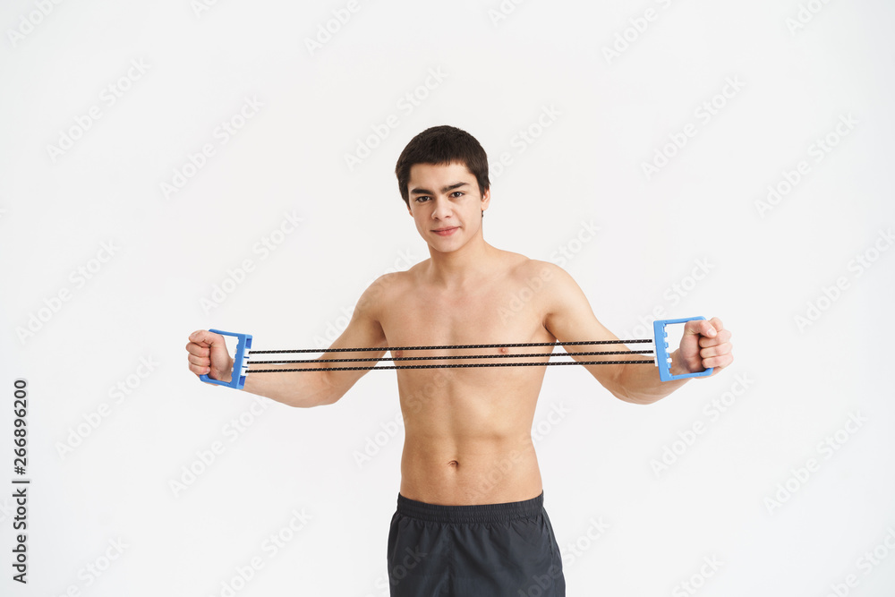 Confident fit young shirtless sportsman doing exercises Confident fit young shirtless sportsman doing exercises