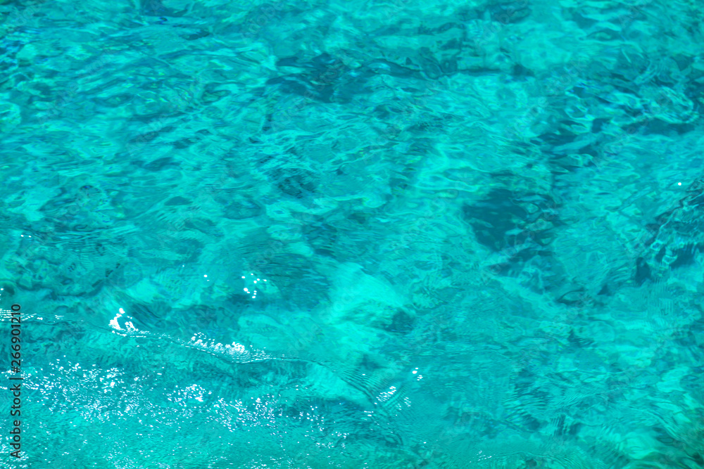 Texture of clear turquoise sea water surface. Can be used as summer background