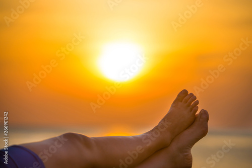 Bare human feet on beautiful sea sunset background. Summer vacation concept