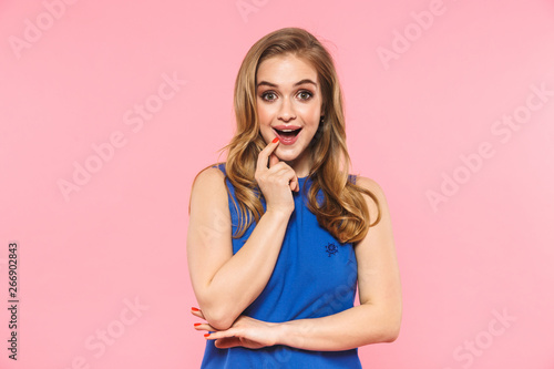 Shocked emotional young pretty woman posing isolated over pink wall background.