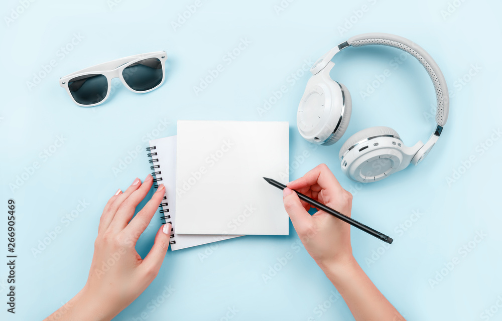Turbine drivende Egern Top view mock up woman's hands with notebook, headphones, glasses on blue  background. Copy space. 'To