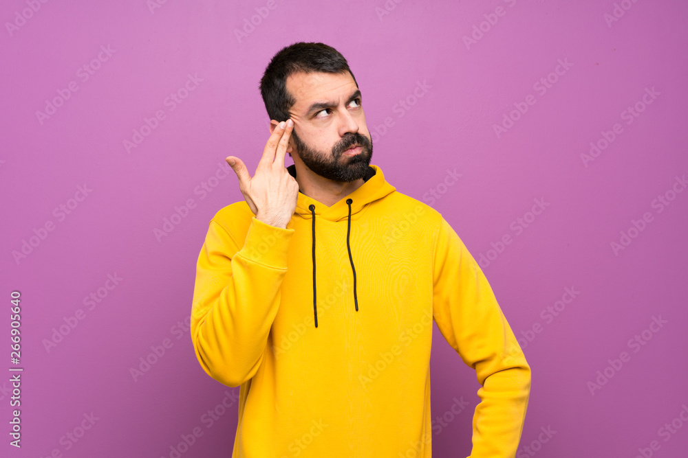 Handsome man with yellow sweatshirt with problems making suicide gesture Handsome man with yellow sweatshirt with problems making suicide gesture