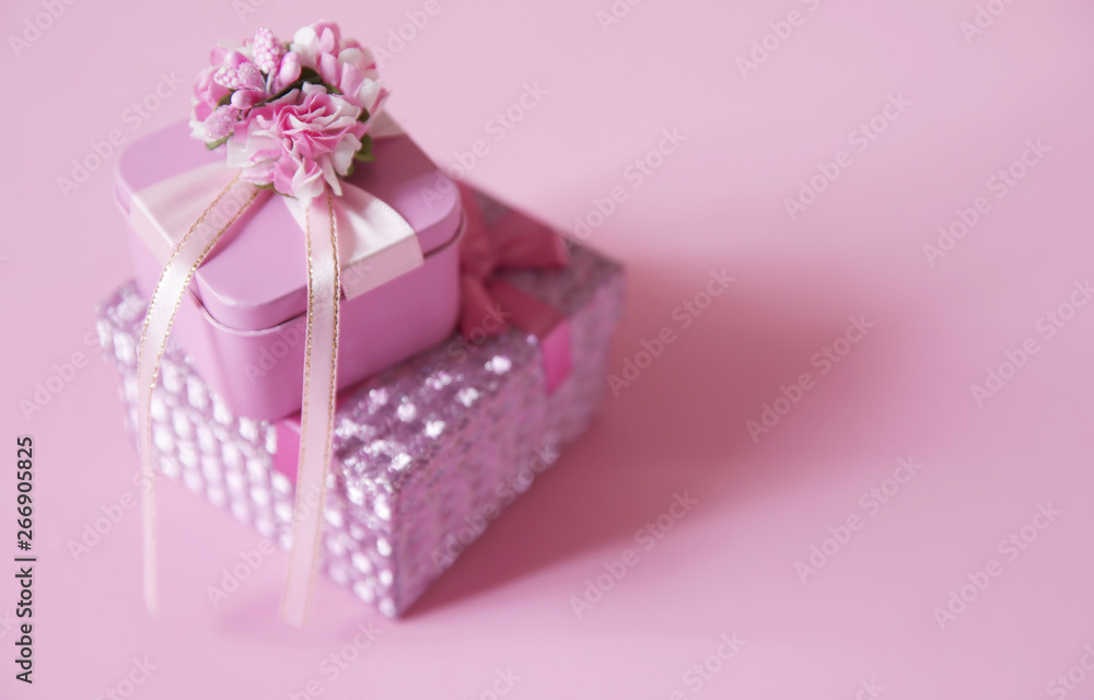 pink gift box with red ribbon and bow and flower isolated on pink background. Copy space.