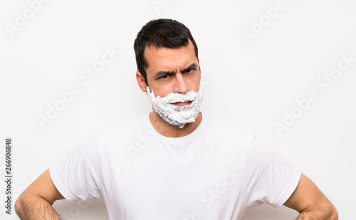 Man shaving his beard over isolated white background angry