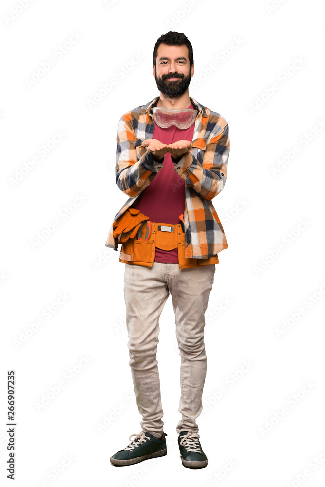 Craftsmen man holding copyspace imaginary on the palm to insert an ad over isolated white background Craftsmen man holding copyspace imaginary on the palm to insert an ad over isolated white background